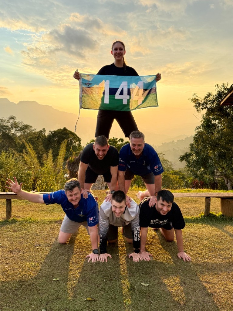 8 Sig members in a human pyramid with unit flag 144