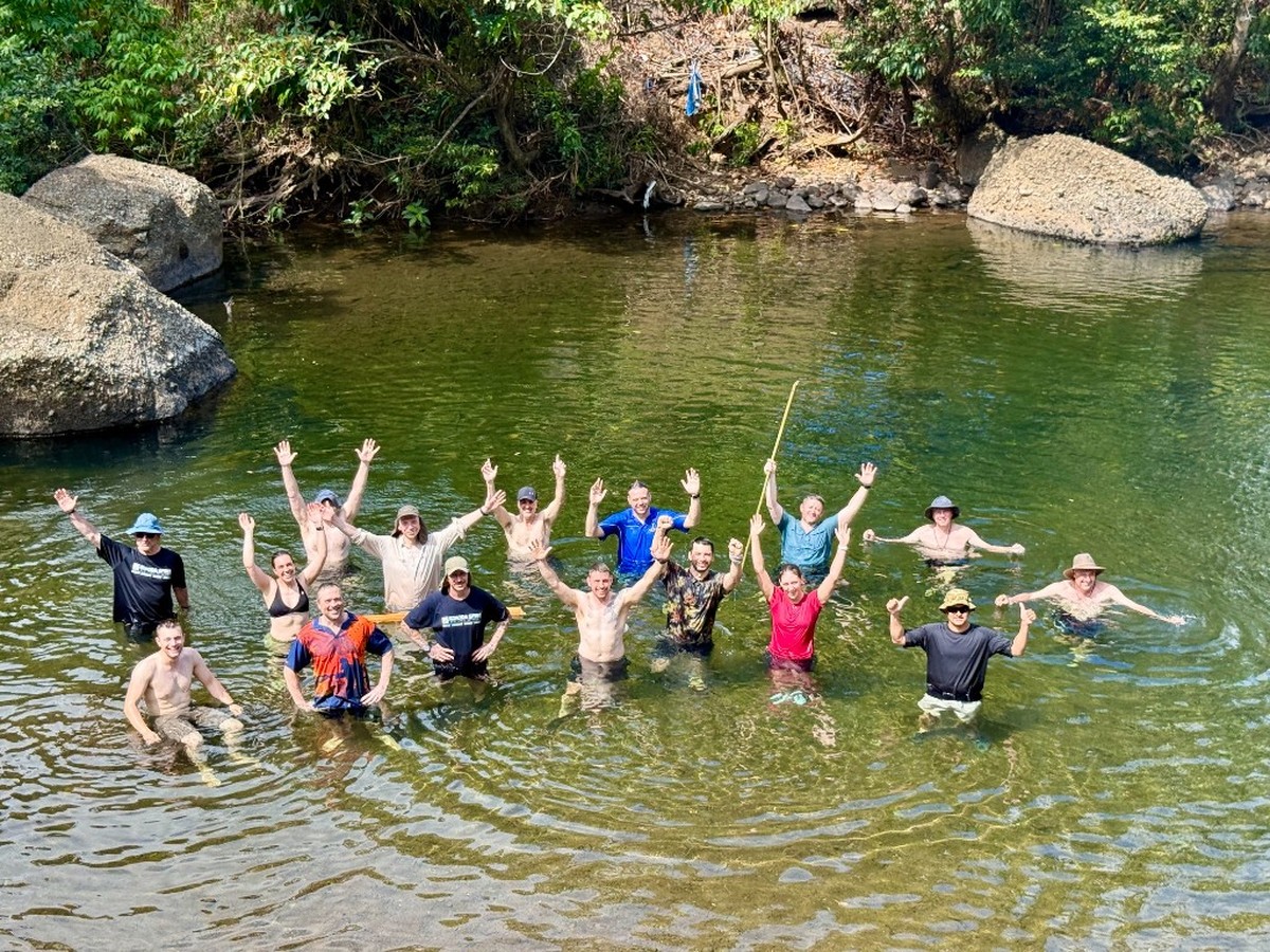 8 Sig members celebrating in a jungle river