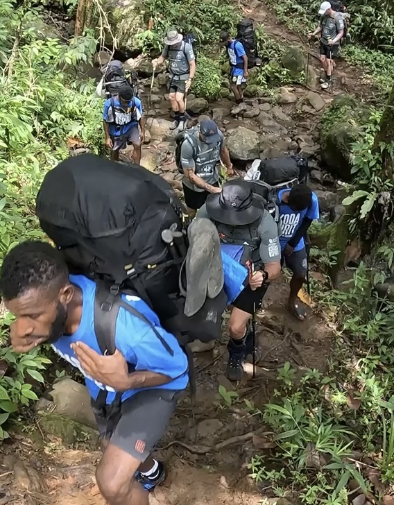 Porters and trekkers ascending a steep Kokoda trail